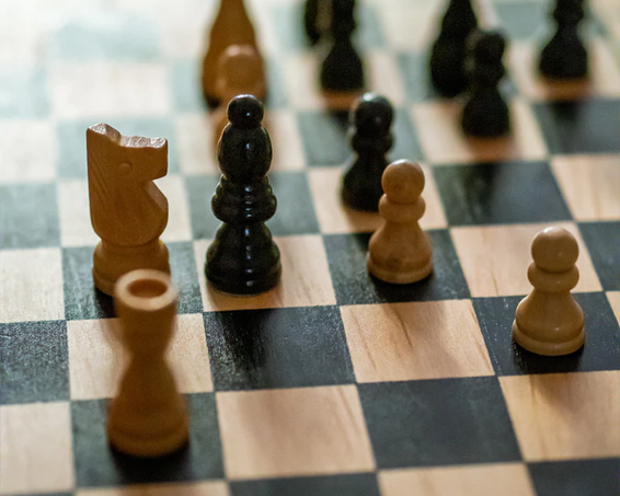 a wooden chess board with pieces in play